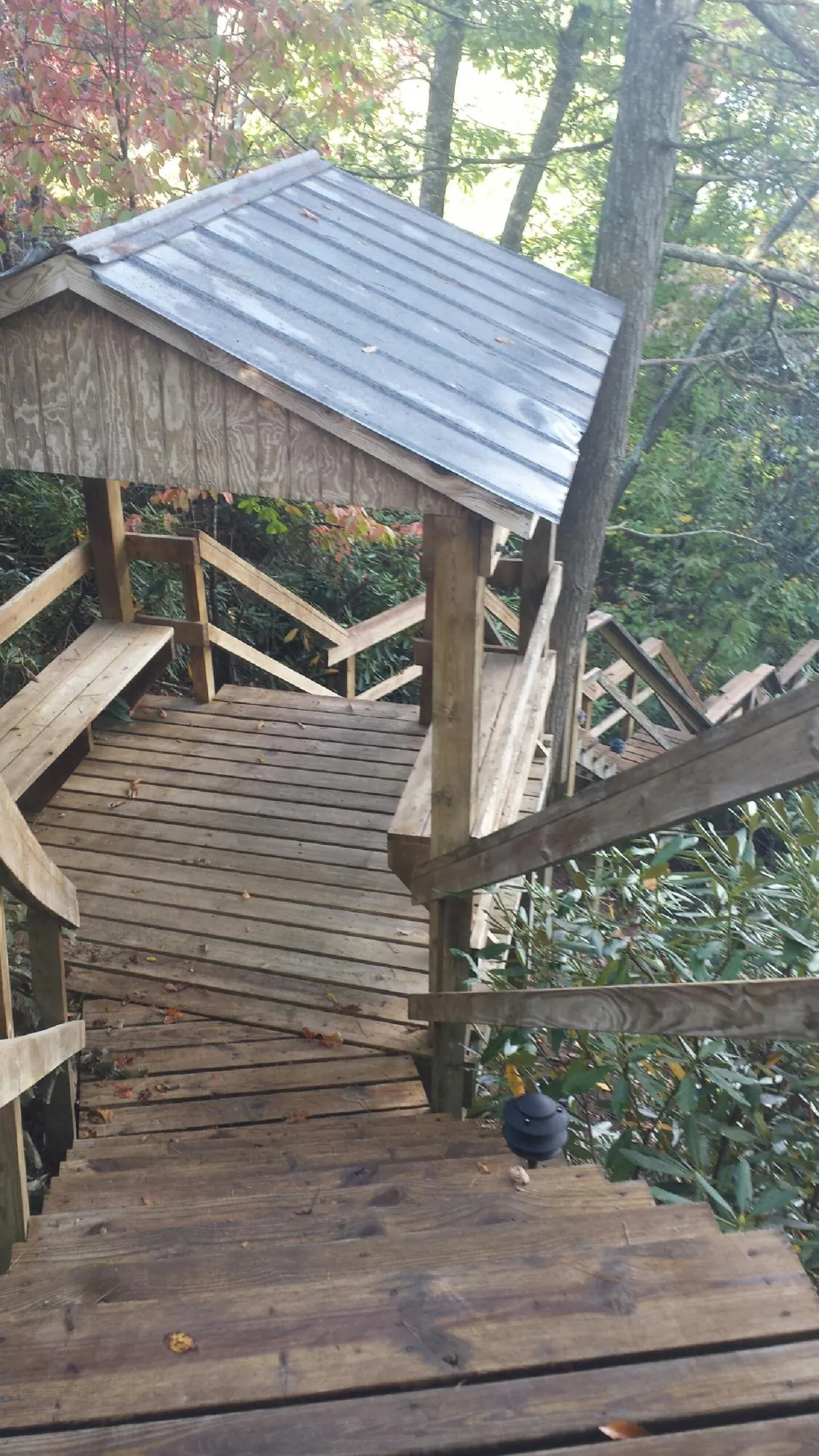 Metal roofed shelter over wooden steps on a wooded walkway — Skylight Repair & Installation work by our crew in Stratton