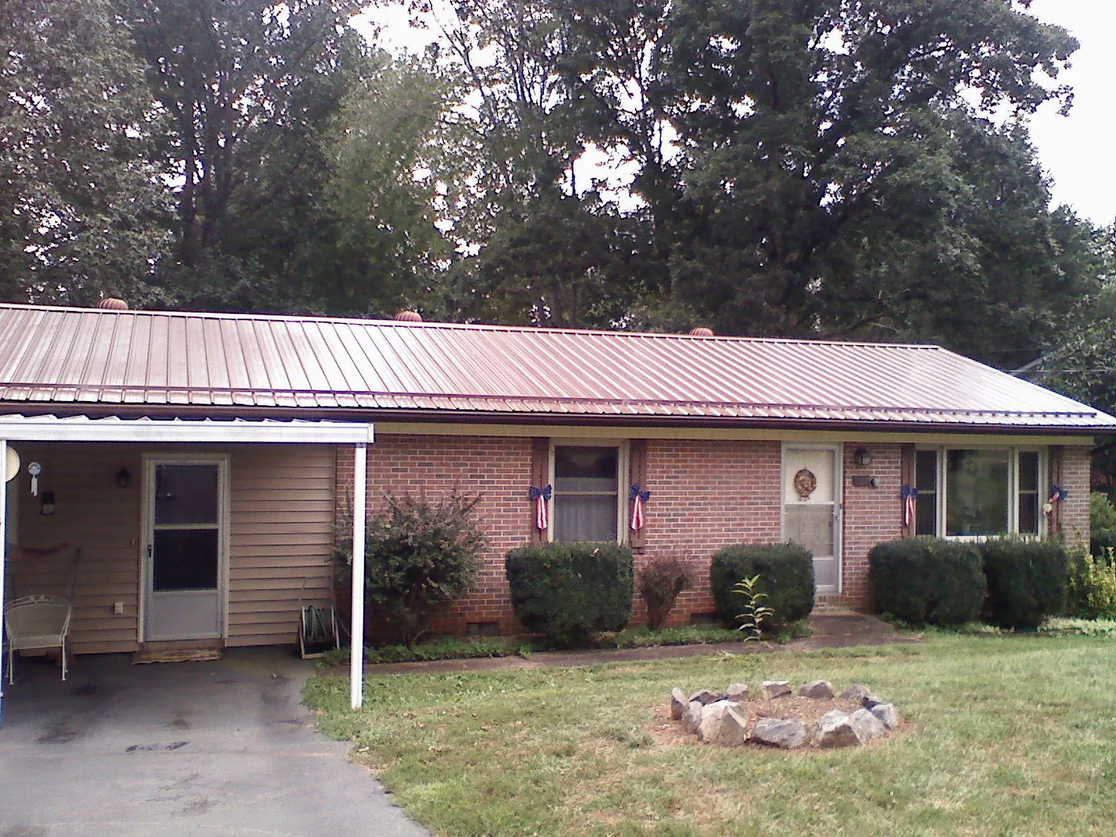 Bronze metal roof and carport on a brick ranch home — Roof Repair work by our crew in Stratton